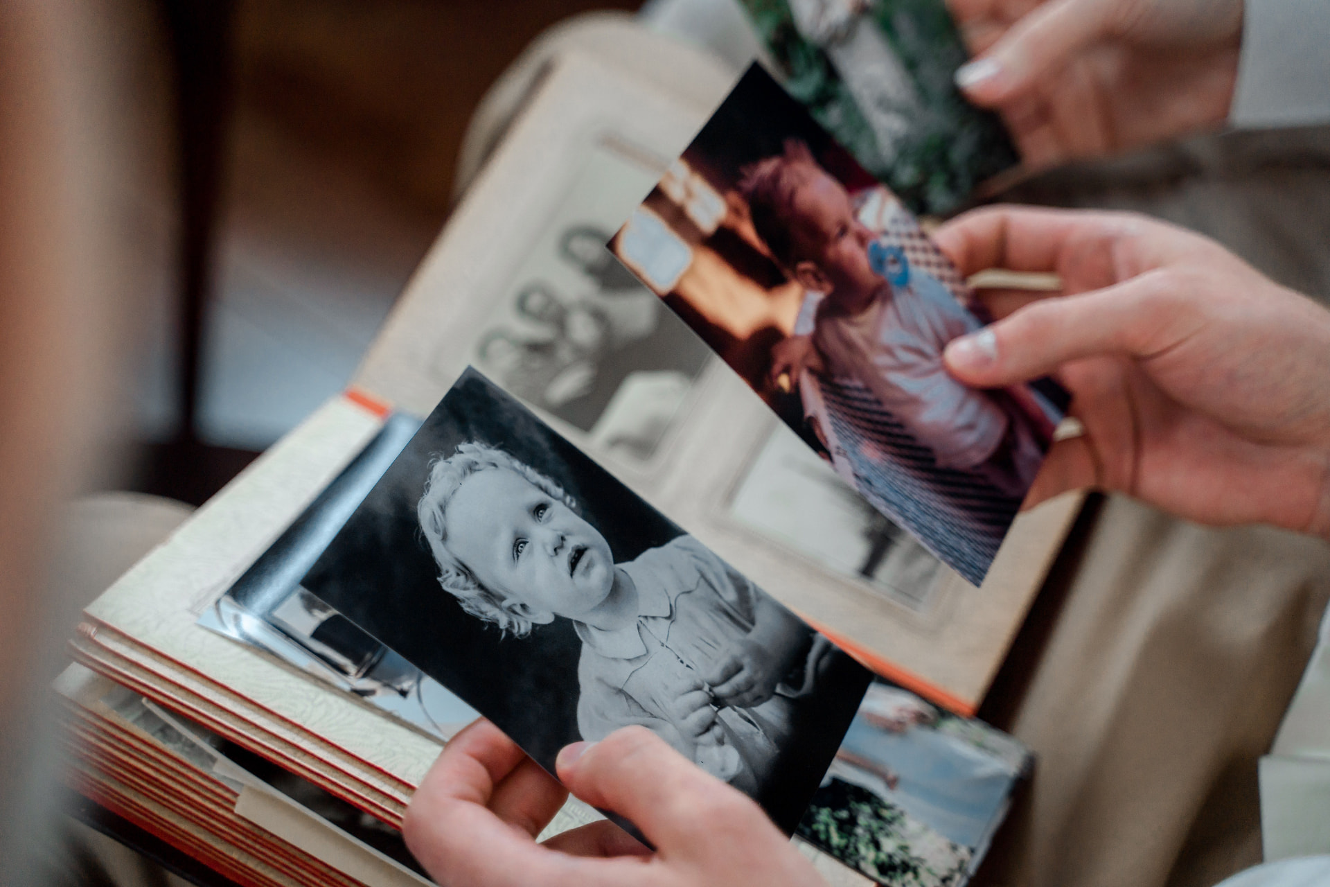 Mains tenant des photographies anciennes dans un album
